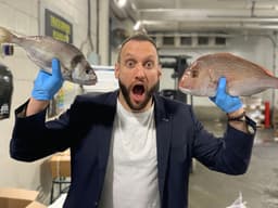 James Heras holding two whole fish